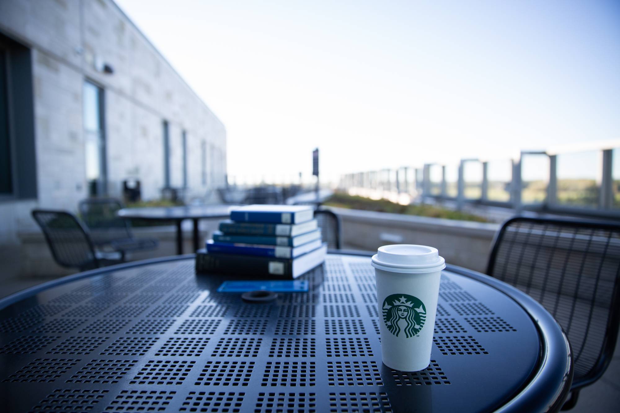 Starbucks coffee and books on outdoor table of Mary Idema Pew Library